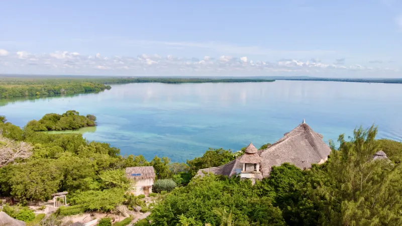 Aerial of the thatched lodges above the turquoise Mida Creek lagoon at Watamu