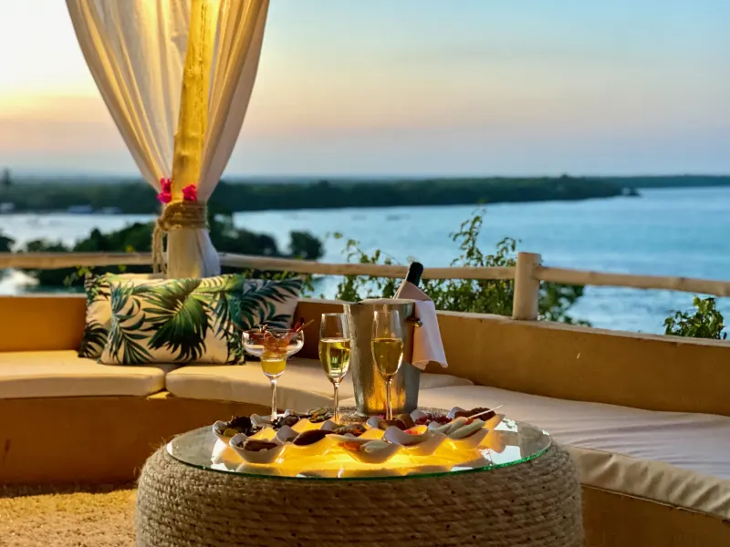 Romantic canopied sunset lounge set for two with champagne overlooking Mida Creek